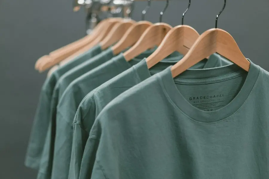 Green cotton tops on wooden hangers