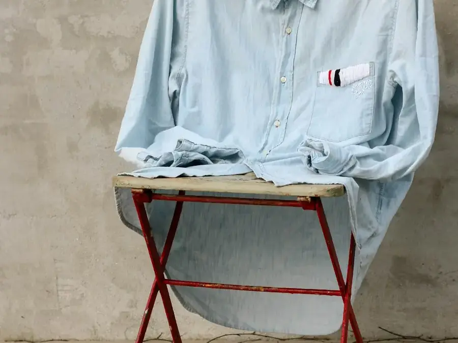 Light blue cotton shirt resting on a folding stool